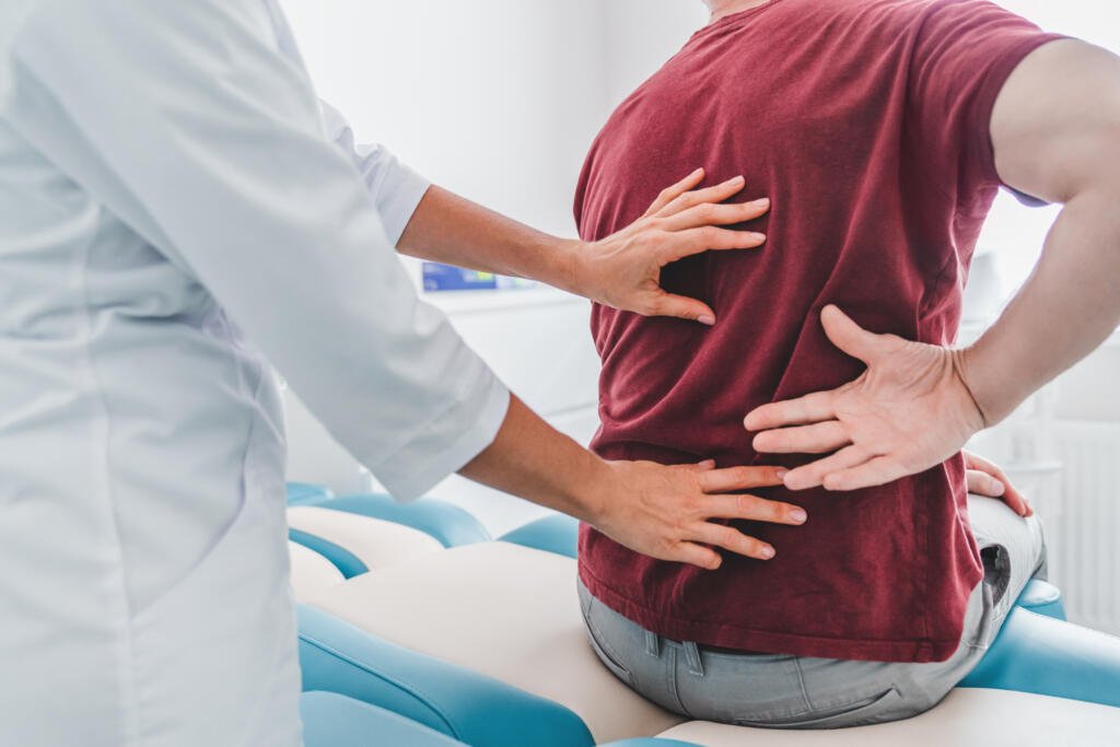 Cropped close up of female orthopedist examining patient's back in clinic - Fizyoterapist Dr. Şule OKUR DÜNDAR